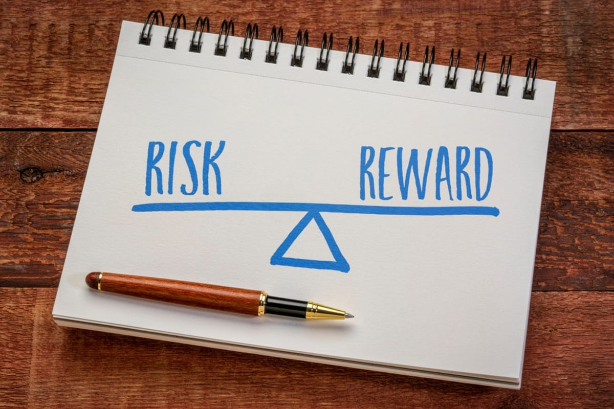 A drawing on a notebook of risk and reward on a balance.