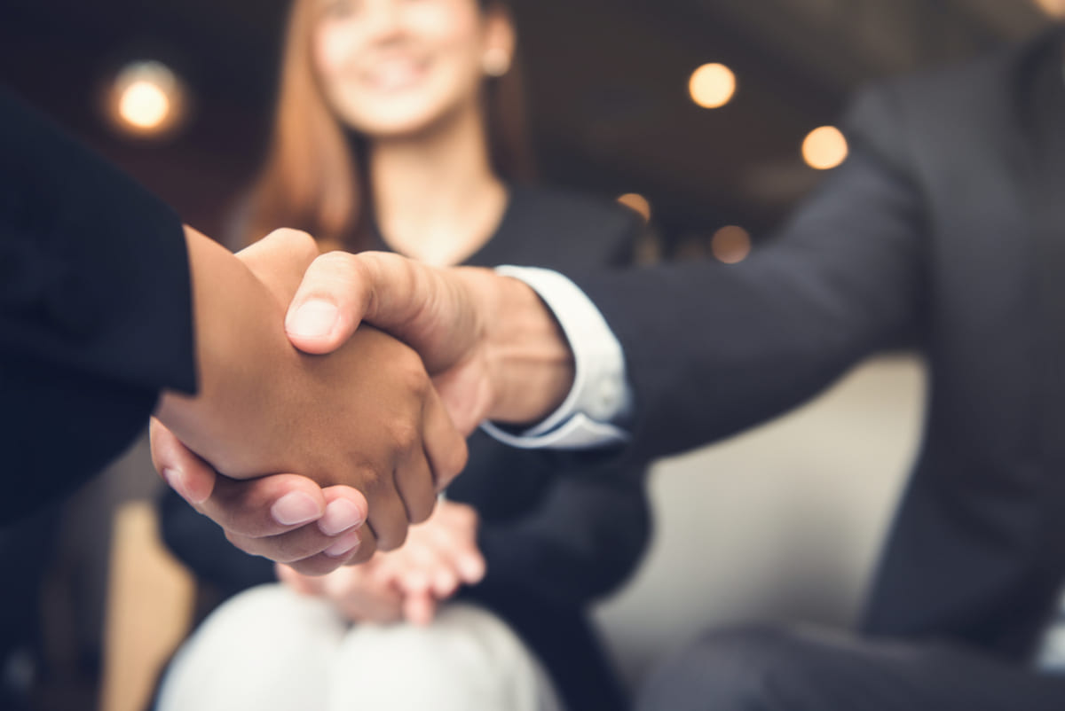 Two people in suits shaking hands.