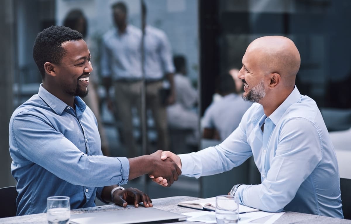 Two people shaking hands in an office