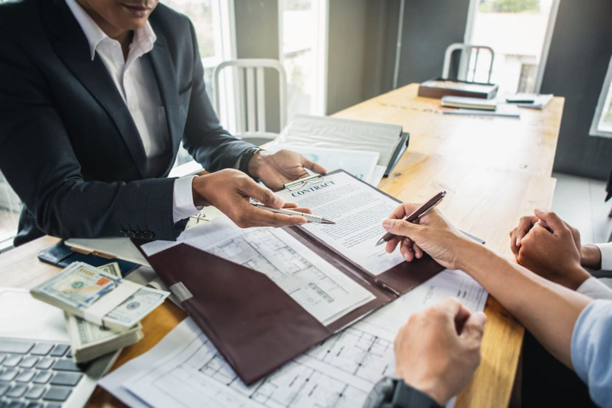 Two people having a meeting and a customer signing a contract